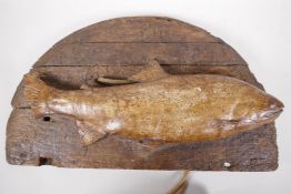 A driftwood wall palque mounted with a ceramic model of a salmon, 18" long