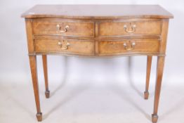An inlaid mahogany serpentine front four drawer canteen, raised on tapering supports, with spade