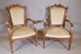 A pair of C19th French walnut show frame arm chairs in  the Grecian style with carved decoration,