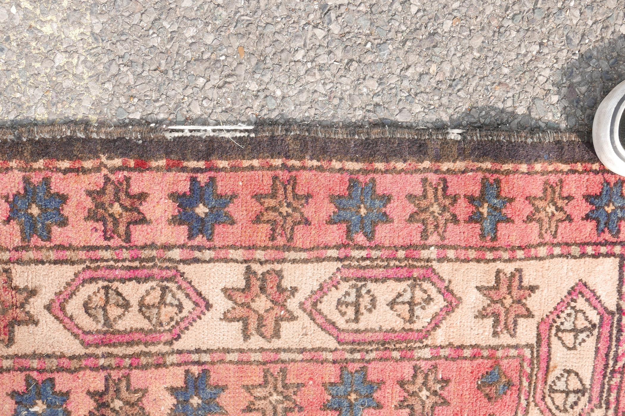 A Persian black ground hand woven wool runner with a repeating rust coloured medallion design within - Image 3 of 6