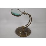 A brass desk top magnifying glass on adjustable stand, 10" high