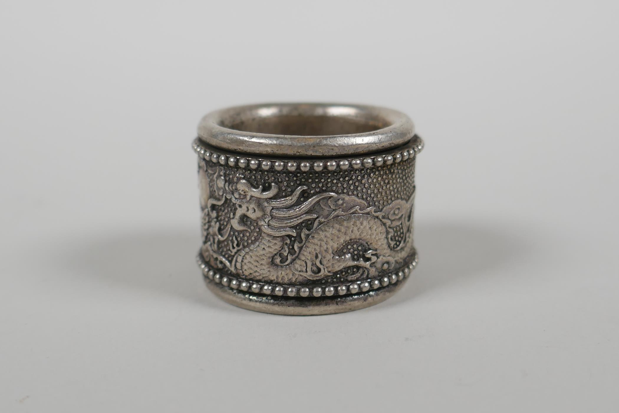 A Chinese white metal archers thumb ring with a revolving cuff decorated with a dragon and - Image 2 of 4
