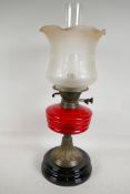 A C19th brass and glass oil lamp with cranberry glass shade, 21" high