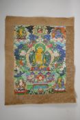 A Tibetan printed thangka with silk borders, 15" x 19"