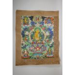 A Tibetan printed thangka with silk borders, 15" x 19"