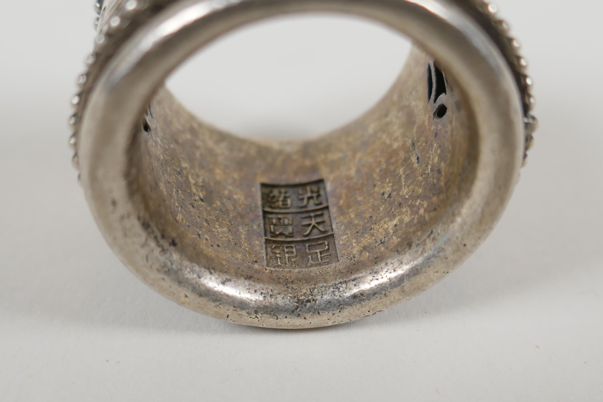 A Chinese white metal archers thumb ring with a revolving cuff decorated with a dragon and - Image 4 of 4