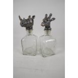 A pair of square section decanterswith plated stoppers, in the form of animal heads. 10" high