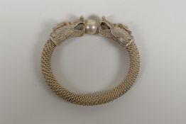 A Chinese white metal wirework bangle decorated with two dragon heads. 3½" x 3"