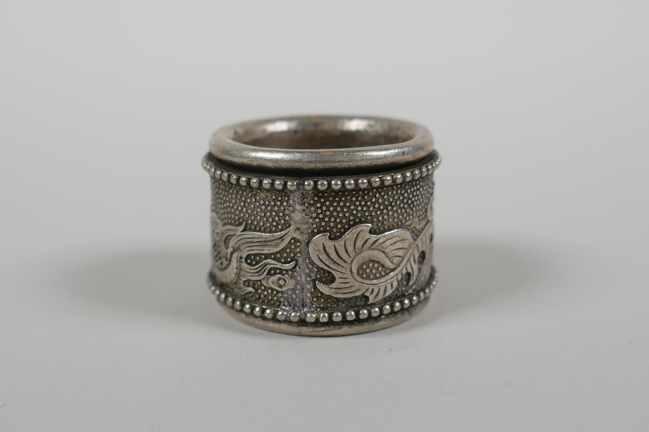A Chinese white metal archers thumb ring with a revolving cuff decorated with a dragon and - Image 3 of 4
