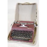 A vintage olympia typewriter in maroon lacquer finish, in original hard case. Excellent condition