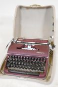 A vintage olympia typewriter in maroon lacquer finish, in original hard case. Excellent condition