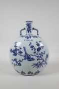 A Ming style blue and white porcelain moon flask, decorated with birds perched on branches in bloom,