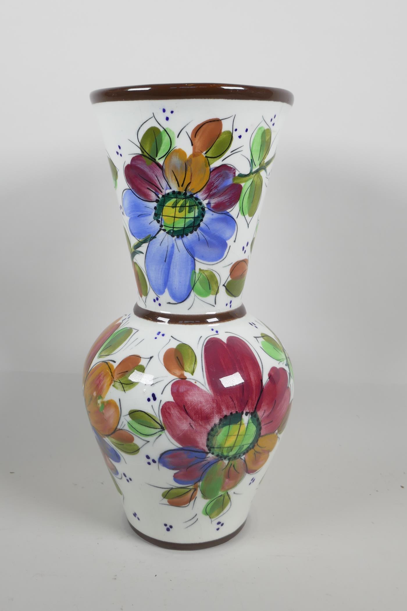 A pottery trumpet vase, hand painted with flowers, 13" high
