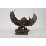 A Tibetan bronze figure of Garuda with remnants of gilt patina, 11" high x 10" wide