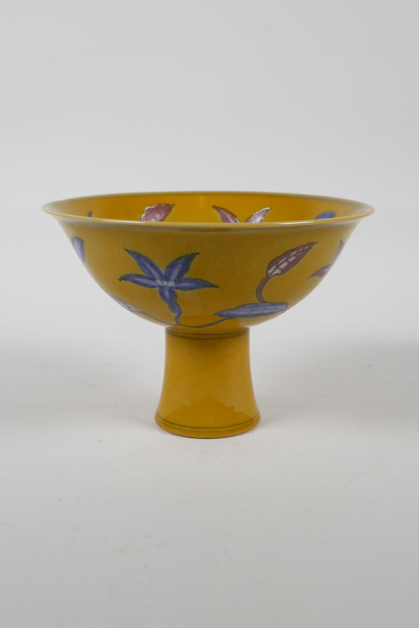 A Chinese yellow ground porcelain stem bowl with red and blue floral decoration, 6 character mark to
