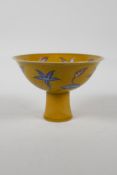 A Chinese yellow ground porcelain stem bowl with red and blue floral decoration, 6 character mark to