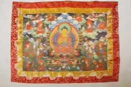 A Tibetan printed Thangka with embroidered silk borders, 44" x 33"