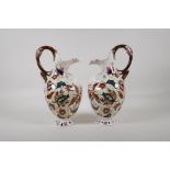 A pair of continental Zsolnay style ewers, decorated with an Iznik design. 11" high