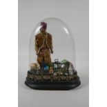 An antique glass dome & stand, containing a diorama of an Eastern gent & his wares. 10" high