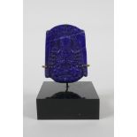 An oriental carved lapis amulet depicting buddha seated in meditation, on a display mount. 3" high