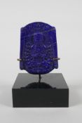 An oriental carved lapis amulet depicting buddha seated in meditation, on a display mount. 3" high