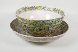 A Persian green ground bowl & charger, with raised polychrome butterfly, bird & floral decoration.