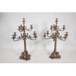 Pair of bronze nine branch candelabra, the arms with ram's mask decoration, raised on fluted columns