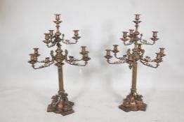 Pair of bronze nine branch candelabra, the arms with ram's mask decoration, raised on fluted columns