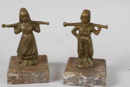 Two small brass/bronze figurines of Dutch Children, carrying yokes on their shoulders, mounted on