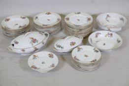 A Limoges floral decorated part dinner service comprising 10" and 12" oval tureens and covers, two