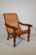 A hardwood and cane plantation chair on turned supports. 37" high