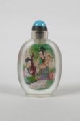 A Chinese reverse decorated glass snuff bottle depicting two women in a garden to each side, 3½"