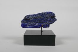 A lapis lazuli carving, in the form of the eye of RA, on a display mount, 2½" wide x 2" high