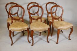 A set of six Victorian walnut balloon back chairs, with carved details. 34" high