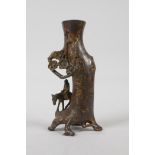 A Chinese bronze spill vase in the form of a traveller beneath a tree, with gilt patina, 6" high