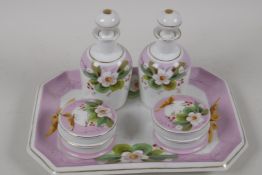 A C19th, continental, porcelain dressing table set. A tray, 10" x 7½". Two toilet water bottles
