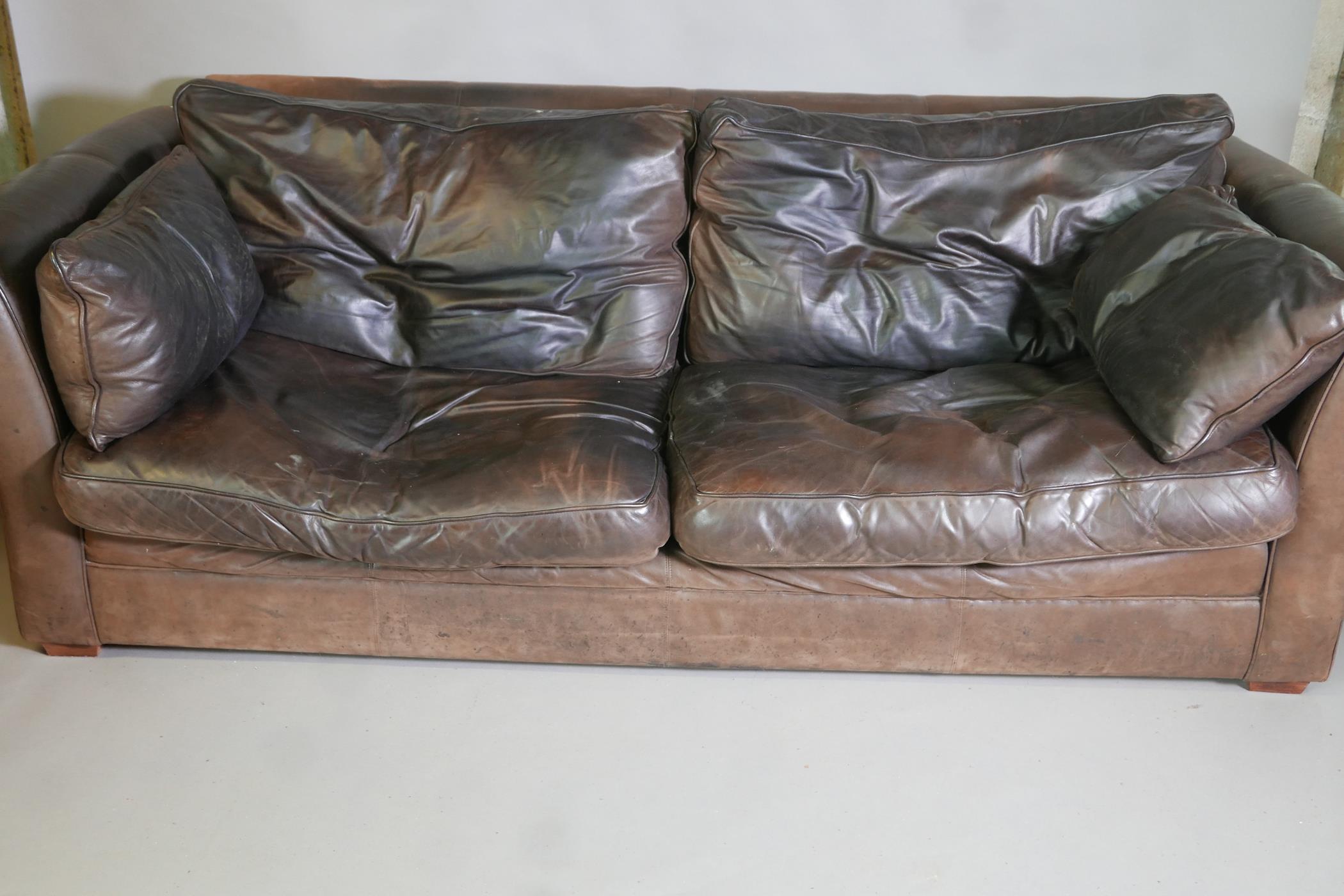 A brown leather three seater settee, 92" long