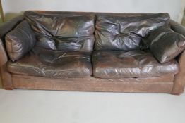 A brown leather three seater settee, 92" long
