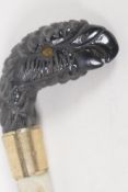 A C19th horn parasol handle, carved as a parrots head. 2" long