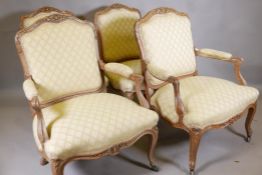 A pair of French style carved beechwood open arm chairs and a matching pair of standards, with