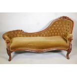 A Victorian button back walnut chaise longue with carved details and legs