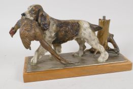 A novelty gold painted metal table lighter, in the form of a gun dog, with pheasant in it's mouth.