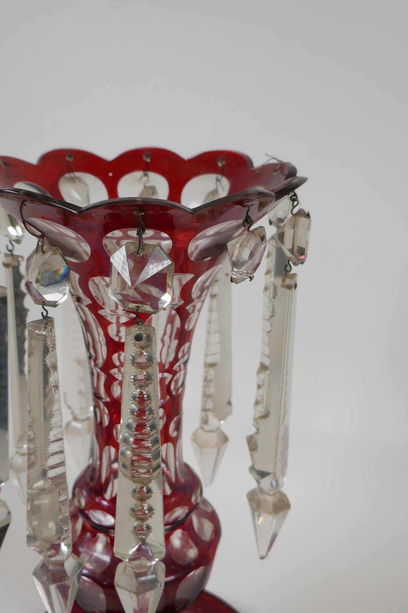 A Bohemian ruby glass lustre with slice cut decoration, 1 lustre missing, 12½" high - Image 3 of 3