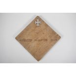 An oak panel with inset hallmarked silver cross potent and the inscription, "Manners Makyth Man".