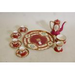 A Vienna style, four place coffee service, with hand painted and raised gilt decoration, on a red