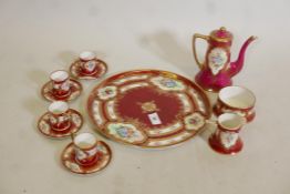 A Vienna style, four place coffee service, with hand painted and raised gilt decoration, on a red