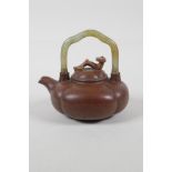 A Chinese Yixing teapot of lobed form with a celadon hardstone handle, the cover with a ruyi knop,