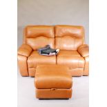 A Sofology two seater reclining leather sofa with pouffe and original care pack, 66" wide