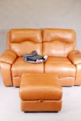 A Sofology two seater reclining leather sofa with pouffe and original care pack, 66" wide