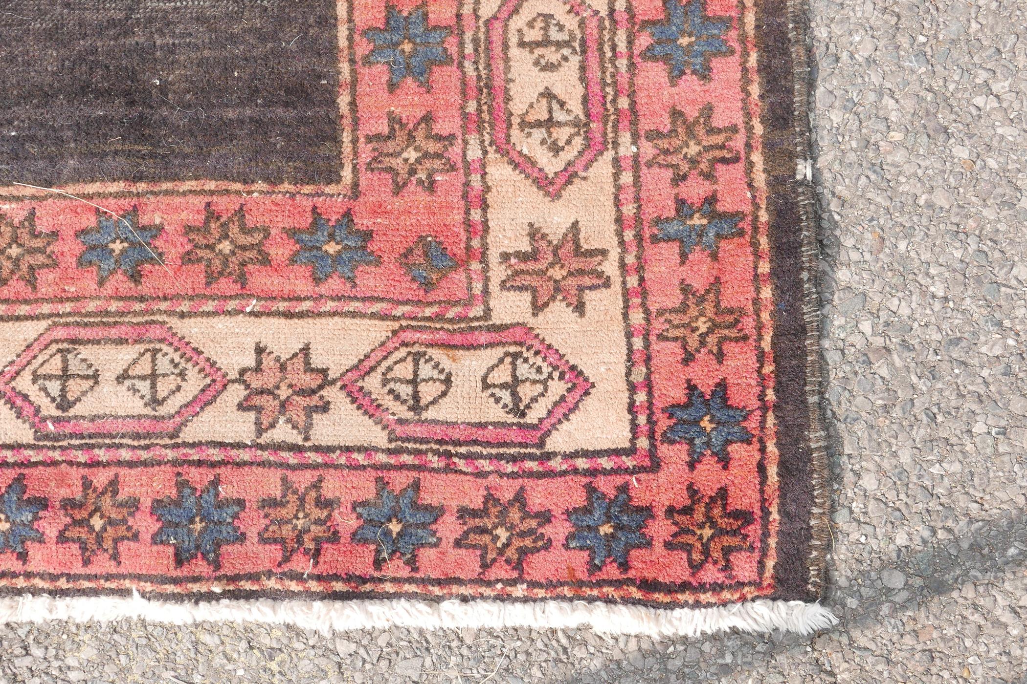 A Persian black ground hand woven wool runner with a repeating rust coloured medallion design within - Image 5 of 6